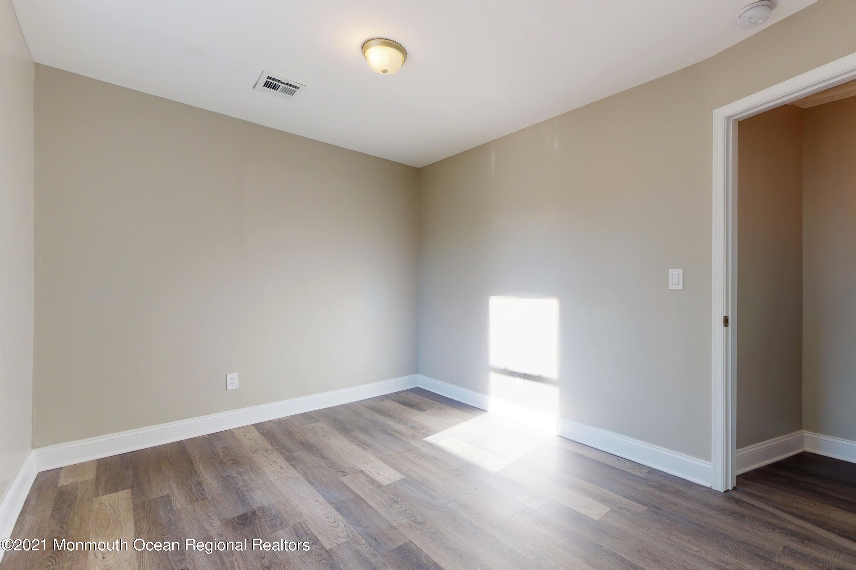 317 Stearman Road Brick, NJ 08723 - Photo 40 of 41 an empty room with wooden floor and windows