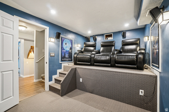 203 North 1900th Street West Mapleton, UT 84664 - Photo 25 of 48 Dedicated home theater space featuring a raised seating platform, integrated wall speakers, and ambient wall sconce lighting