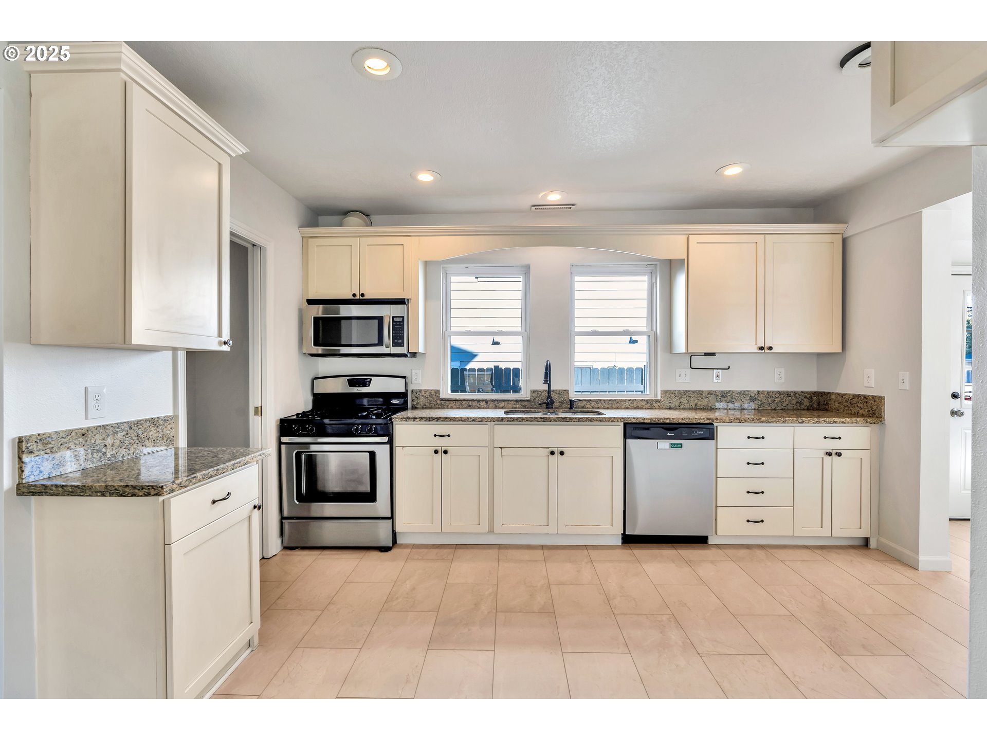 1307 North Kilpatrick Street Portland, OR 97217 - Photo 13 of 46 a kitchen with granite countertop white cabinets and white appliances