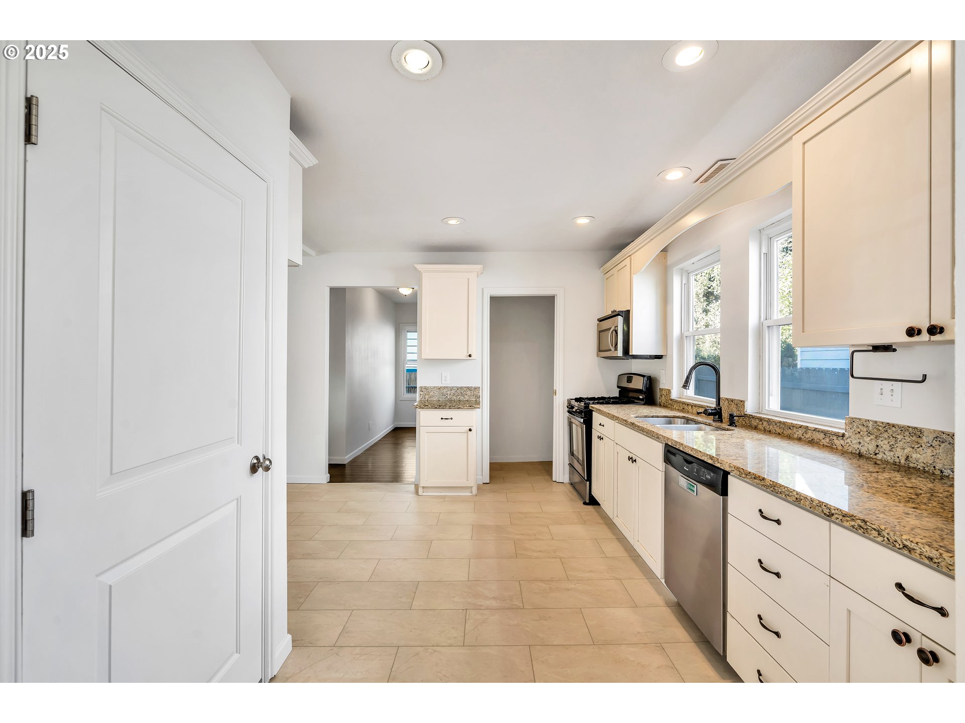 1307 North Kilpatrick Street Portland, OR 97217 - Photo 14 of 46 a large white kitchen with stainless steel appliances granite countertop a large counter top a sink and a refrigerator