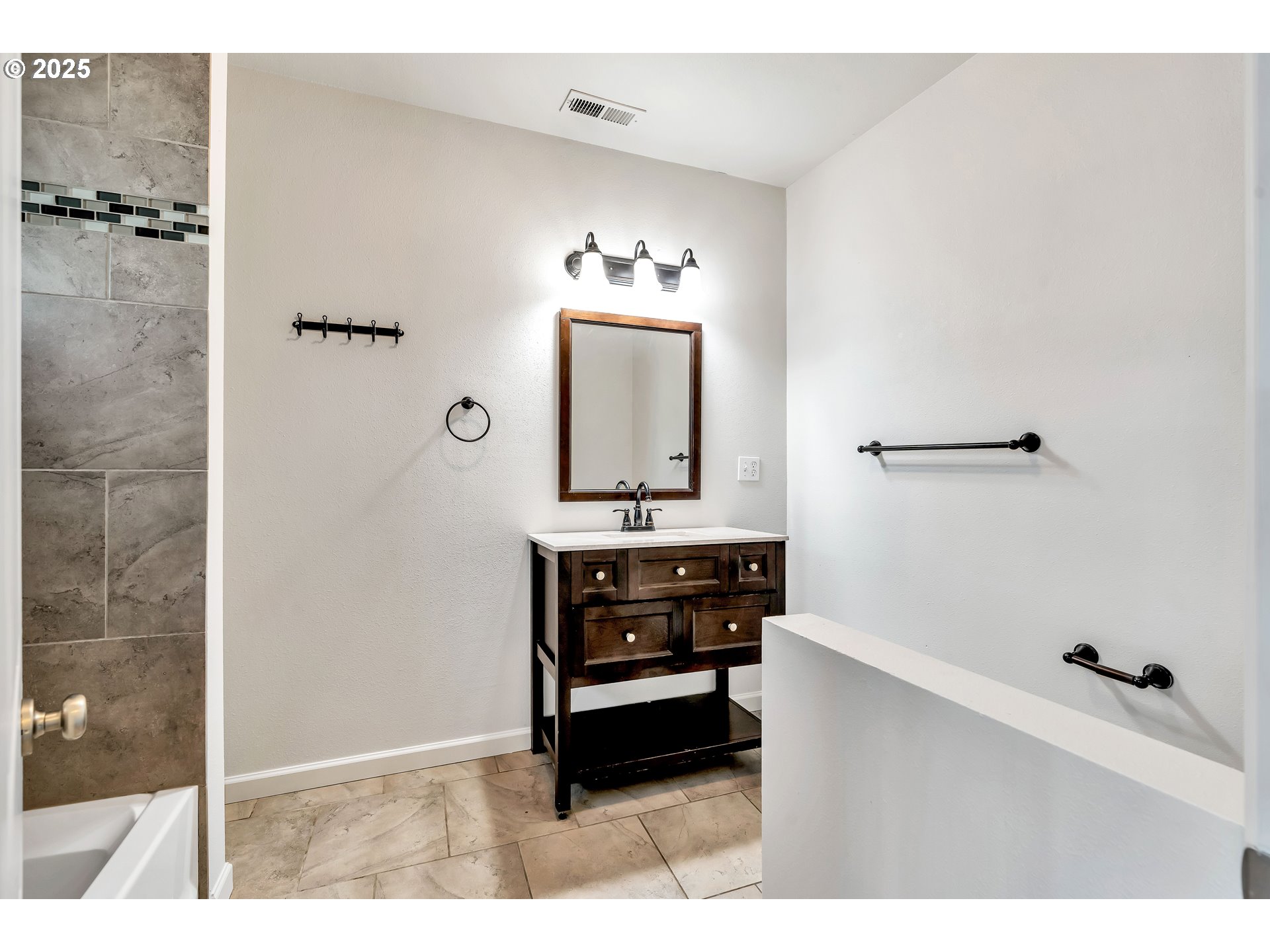 1307 North Kilpatrick Street Portland, OR 97217 - Photo 16 of 46 a bathroom with a sink a mirror and shower