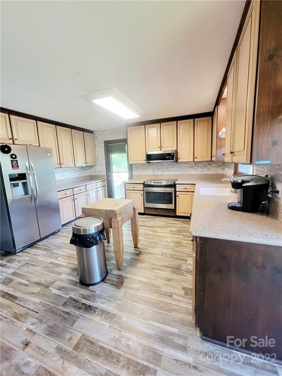 2211 Camden Road Wingate, NC 28174 - Photo 8 of 21 a kitchen with stainless steel appliances kitchen island granite countertop a refrigerator and a stove