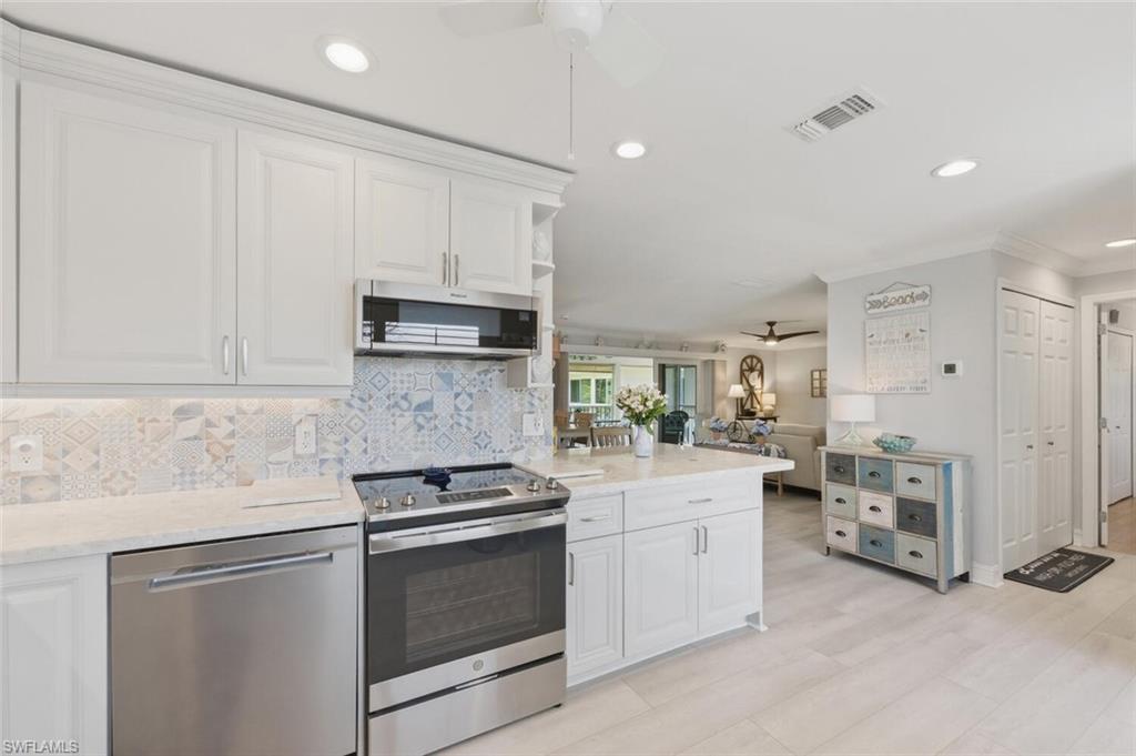 500 Teryl Road, Unit 2312 Naples, FL 34112 - Photo 5 of 46 Kitchen featuring ceiling fan, stainless steel appliances, white cabinetry, crown molding, and recessed lighting