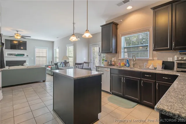 a kitchen with a sink a counter top space appliances and cabinets