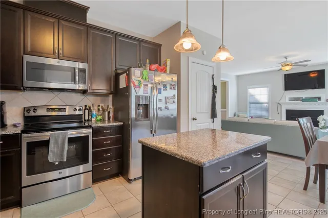 a kitchen with a center island and stainless steel appliances