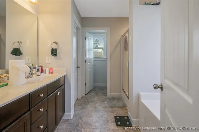 a spacious bathroom with a double vanity sink a mirror and a shower