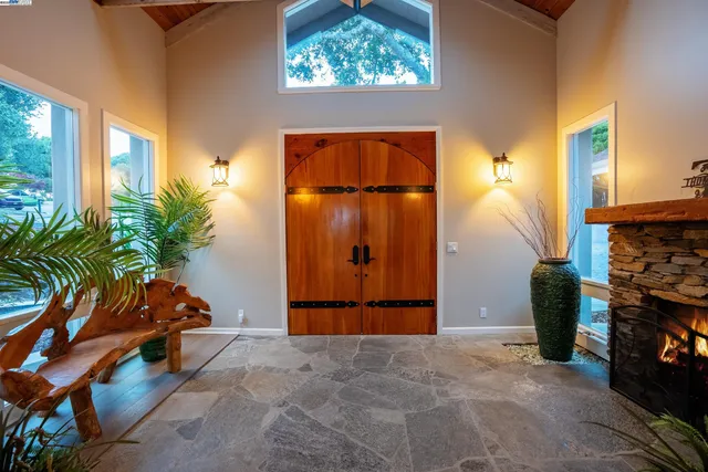 an empty room with potted plants and a fireplace