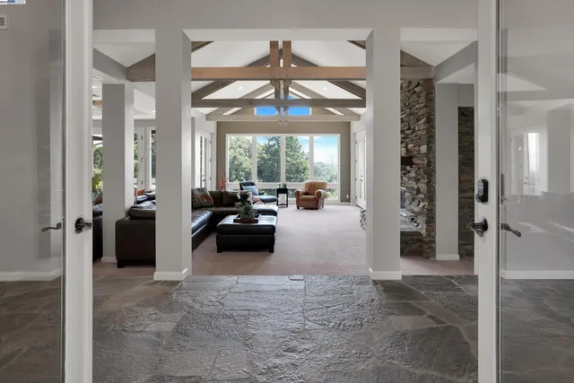 a living room with furniture and floor to ceiling windows
