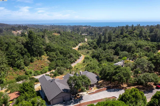 an aerial view of a house with a yard and lake view