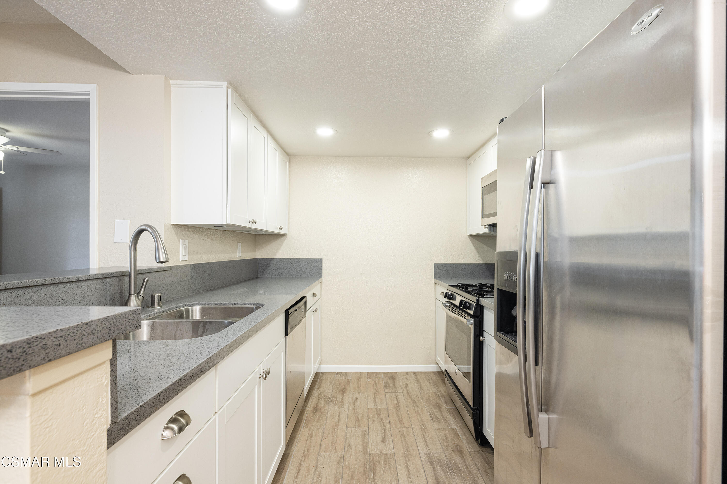 1125 Fitzgerald Road, Unit F Simi Valley, CA 93065 - Photo 14 of 25 a kitchen with stainless steel appliances granite countertop a sink and a refrigerator