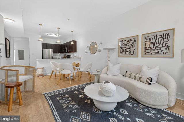 a living room with furniture a rug and kitchen view