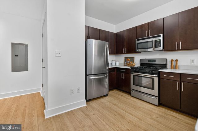 a kitchen with stainless steel appliances granite countertop a refrigerator stove and microwave