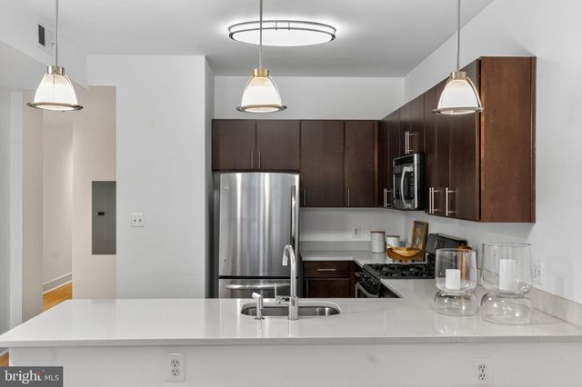 a kitchen with kitchen island granite countertop a sink and refrigerator