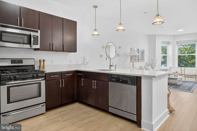 a kitchen with stainless steel appliances granite countertop a sink a stove and a microwave oven with cabinets