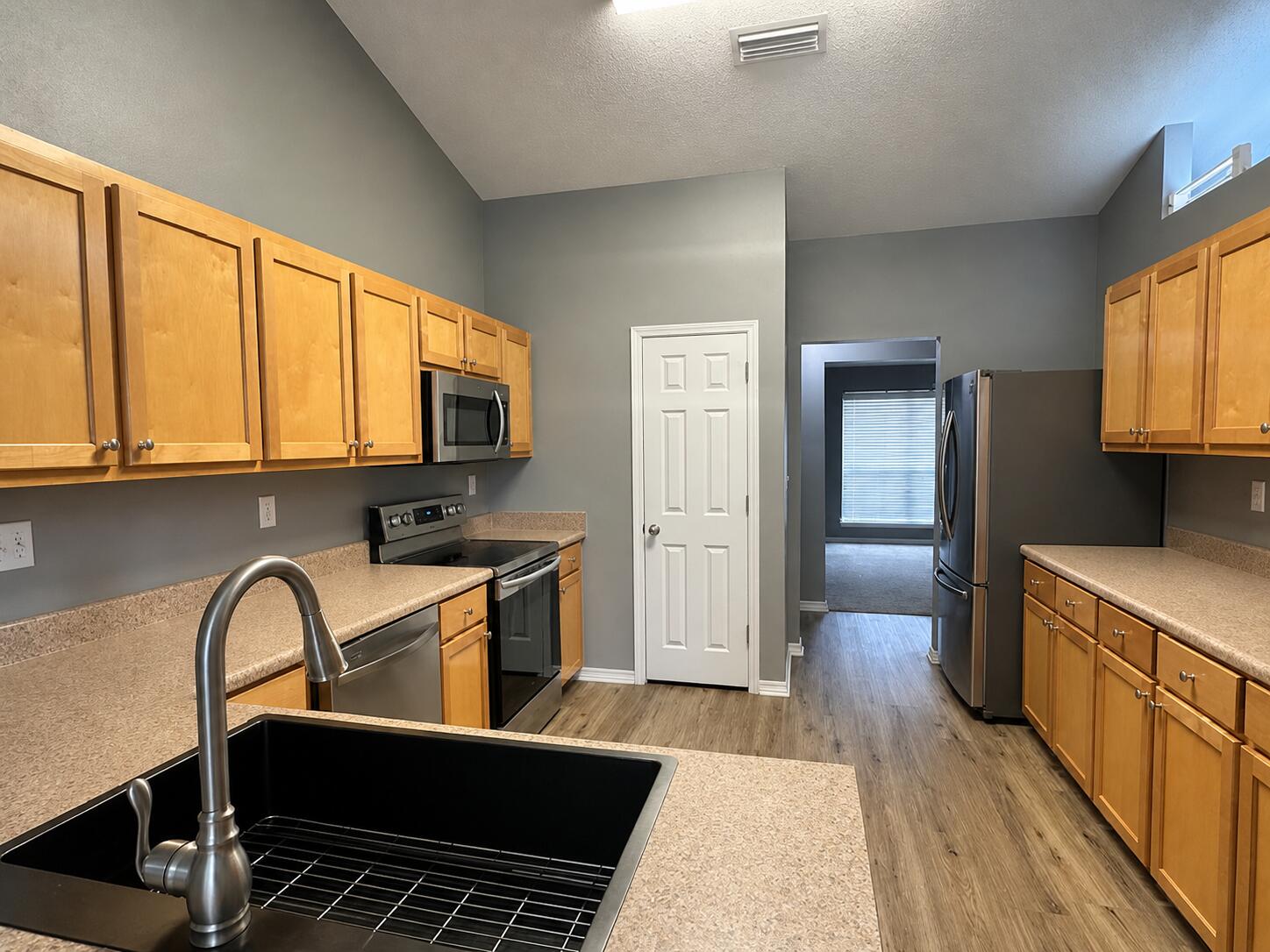 2155 Hagood Loop Crestview, FL 32536 - Photo 5 of 16 a kitchen with stainless steel appliances granite countertop a stove top oven a sink dishwasher a dining table and chairs with wooden floor
