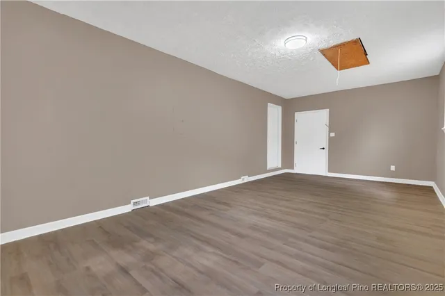 a view of empty room with wooden floor