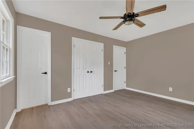 a view of a room with wooden floor and a ceiling fan
