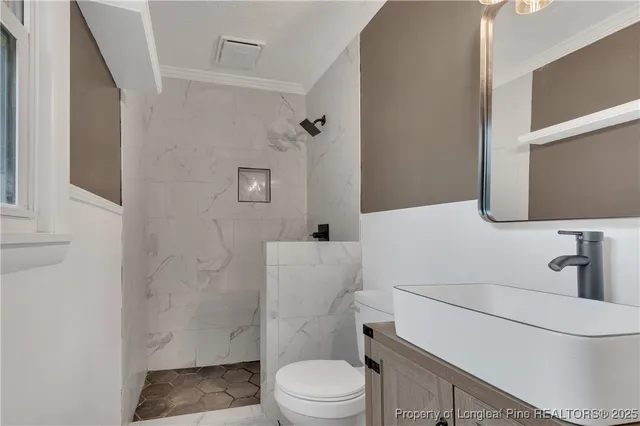 a white toilet sitting next to a bathroom sink