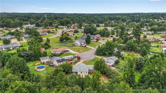 an aerial view of residential houses with outdoor space and trees