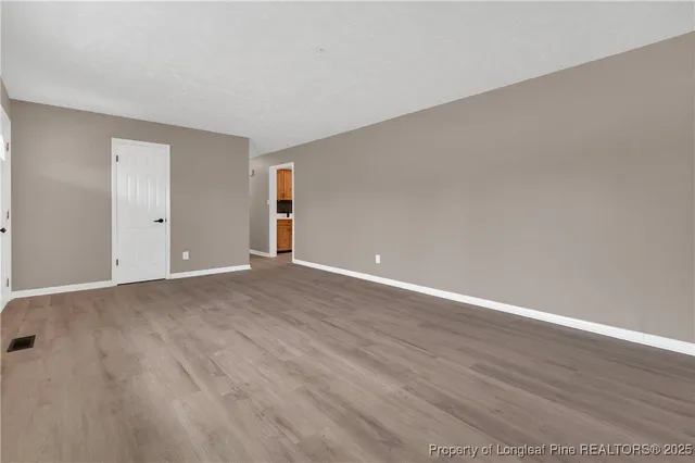 a view of an empty room with wooden floor
