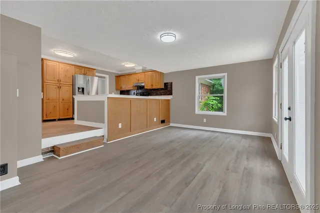 an empty room with a window and wooden floor