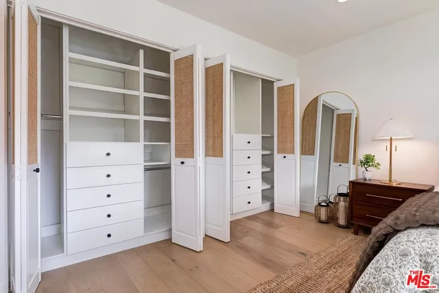 a spacious bedroom with a bed and a dresser