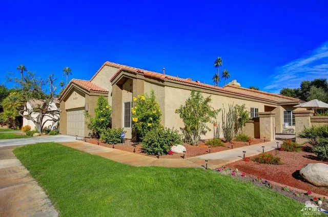 a front view of a house with a garden