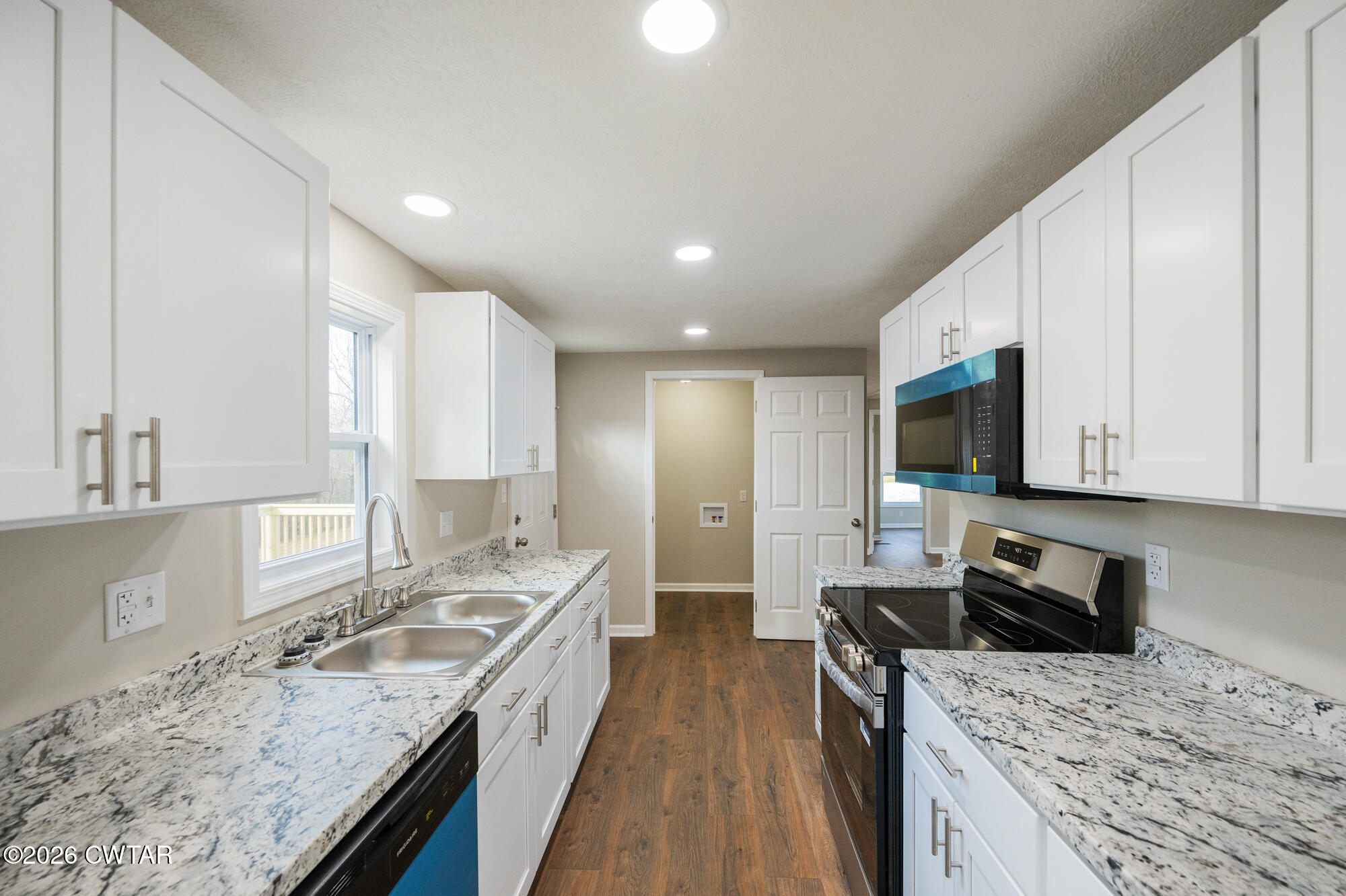 992 Greenway Road Huron, TN 38345 - Photo 10 of 17 a kitchen with granite countertop a sink a counter top space appliances and cabinets