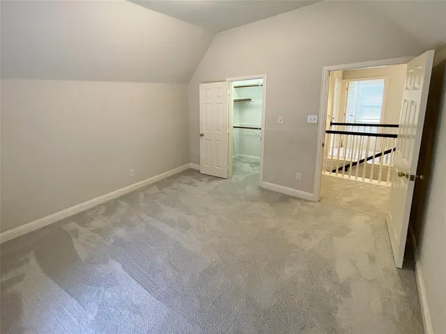 an empty room with a chandelier fan and windows