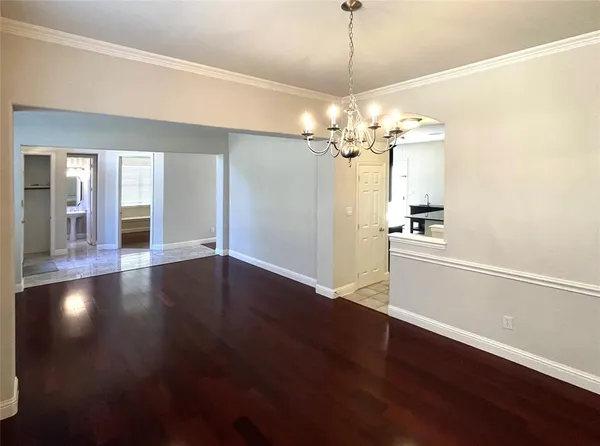 a view of a room with wooden floor and a ceiling fan