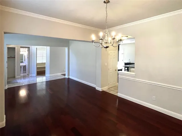 a view of a room with wooden floor and a ceiling fan