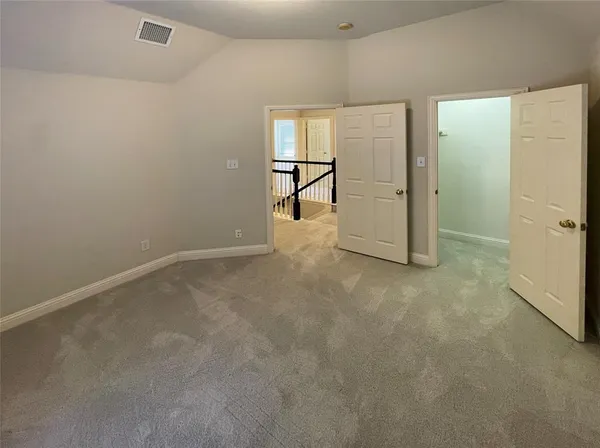 an empty room with windows and refrigerator