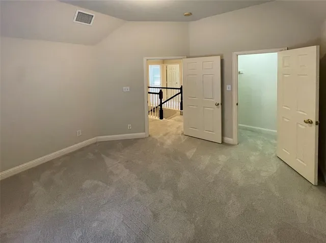 an empty room with windows and refrigerator