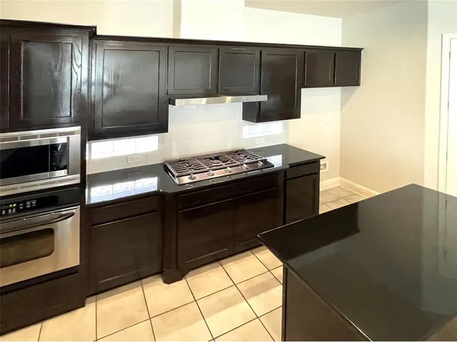 a kitchen with granite countertop a stove and a refrigerator