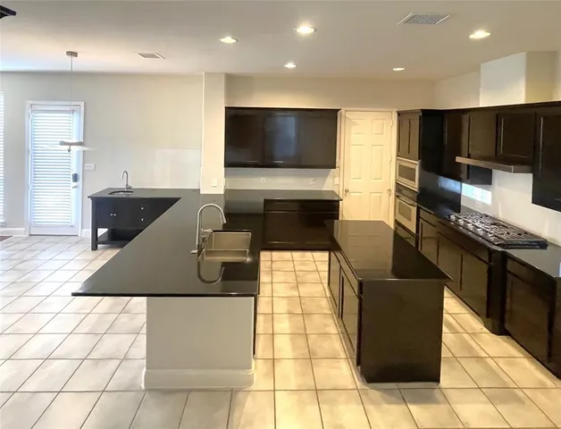 a kitchen with stainless steel appliances a stove a sink and a microwave