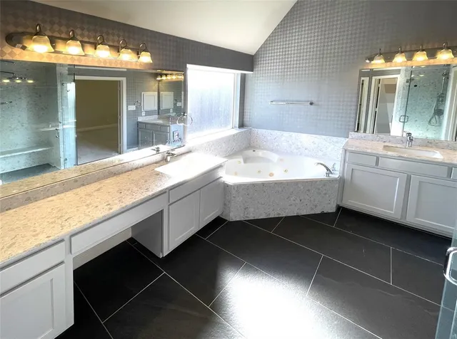 a bathroom with a sink a large mirror and a bathtub