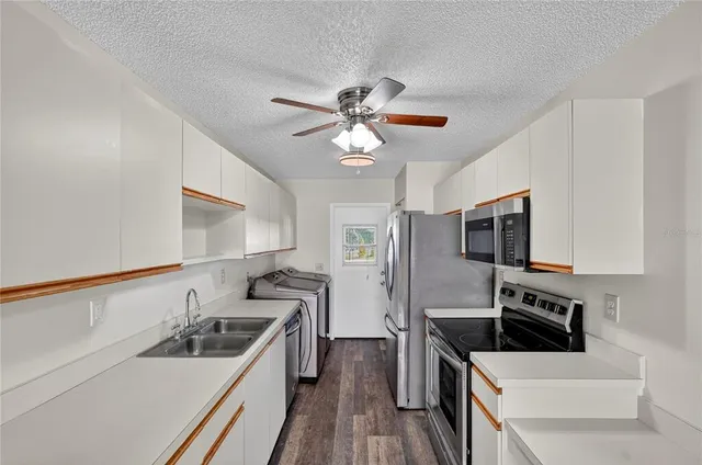 a kitchen with stainless steel appliances granite countertop a sink and a refrigerator
