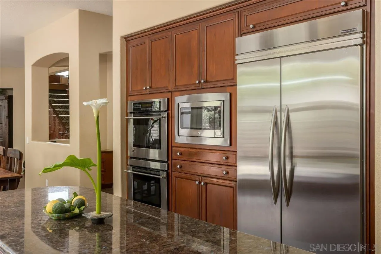 1505 Chateau Lafite Bonsall, CA 92003 - Photo 16 of 47 a kitchen with stainless steel appliances kitchen island granite countertop a refrigerator and a stove