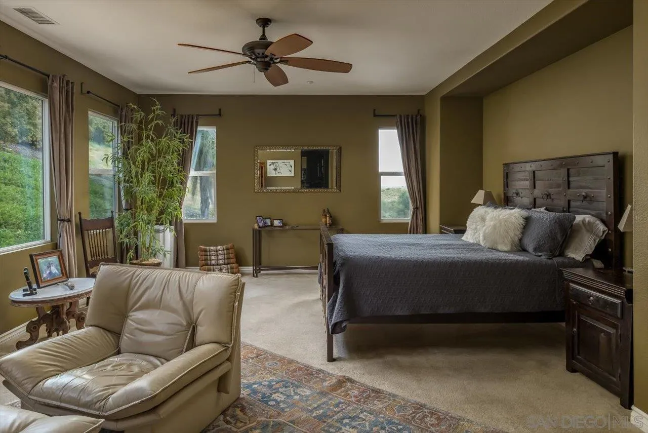 1505 Chateau Lafite Bonsall, CA 92003 - Photo 20 of 47 a bedroom with a bed a couch and a window