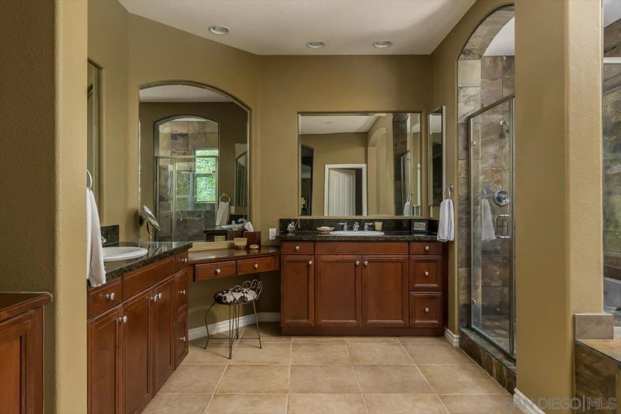 1505 Chateau Lafite Bonsall, CA 92003 - Photo 23 of 47 a large bathroom with a double vanity sink and a mirror
