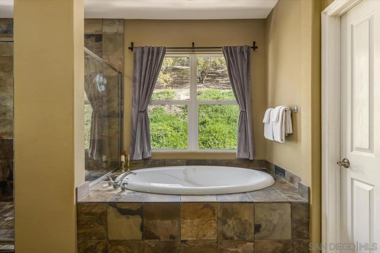 1505 Chateau Lafite Bonsall, CA 92003 - Photo 24 of 47 a bathroom with a granite countertop sink and mirror with bathtub