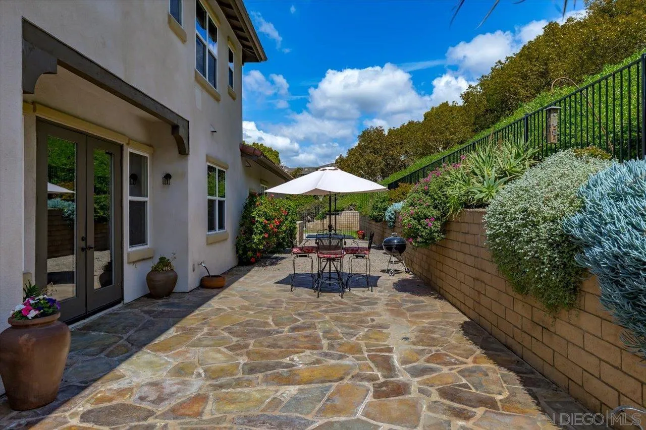 1505 Chateau Lafite Bonsall, CA 92003 - Photo 36 of 47 a view of a patio with table and chairs under an umbrella with wooden floor