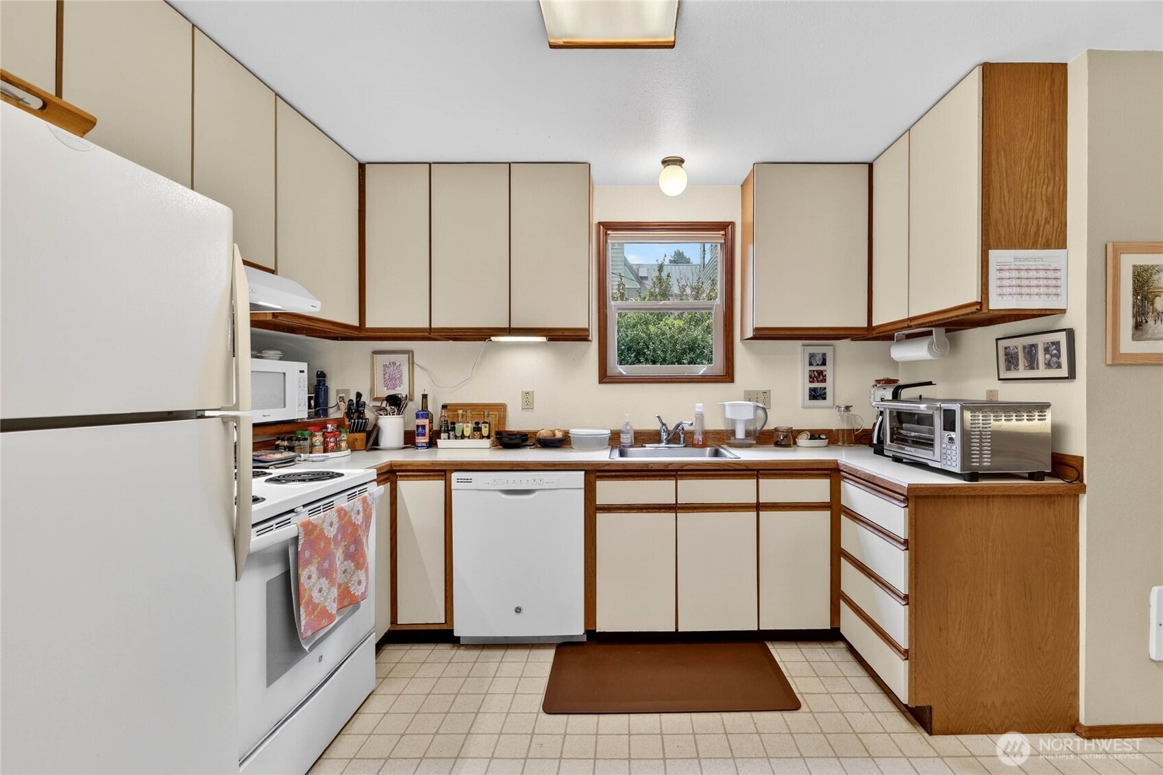 2434 55th Avenue Southwest Seattle, WA 98116 - Photo 18 of 40 a kitchen with stainless steel appliances granite countertop a sink and a refrigerator