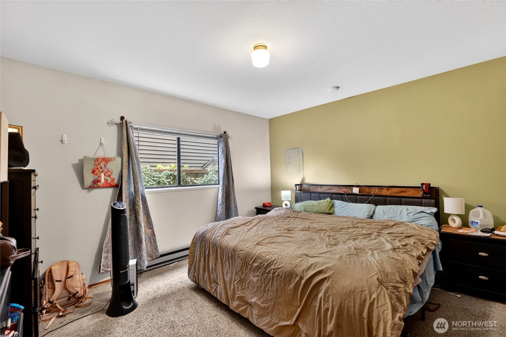 2434 55th Avenue Southwest Seattle, WA 98116 - Photo 10 of 40 a bedroom with a bed and a flat tv screen on the dresser
