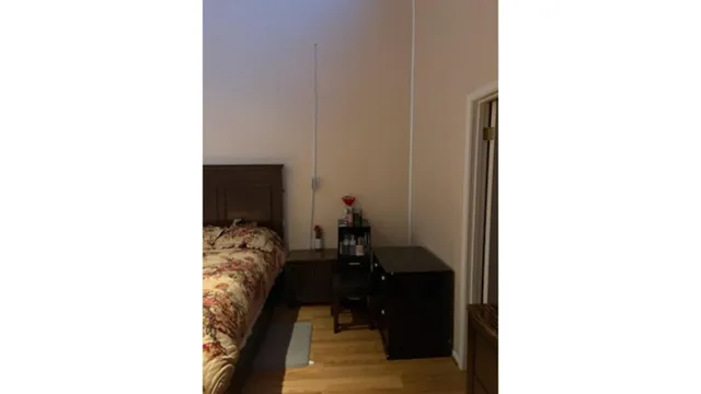 a bed sitting in a bedroom next to a white wall