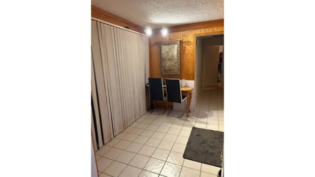 a picture of a room with a door and a white wall