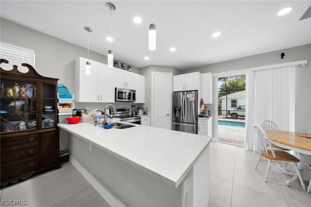 26951 North Riverside Drive Bonita Springs, FL 34135 - Photo 11 of 50 a kitchen with counter top space cabinets and stainless steel appliances