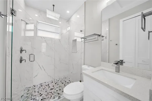 a bathroom with a sink a toilet and shower