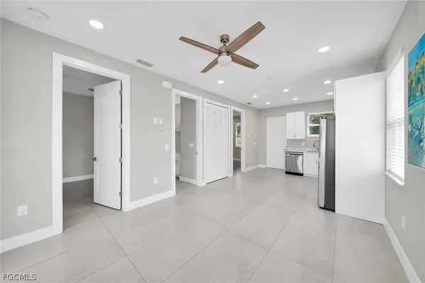 a view of a livingroom with a ceiling fan & entryway