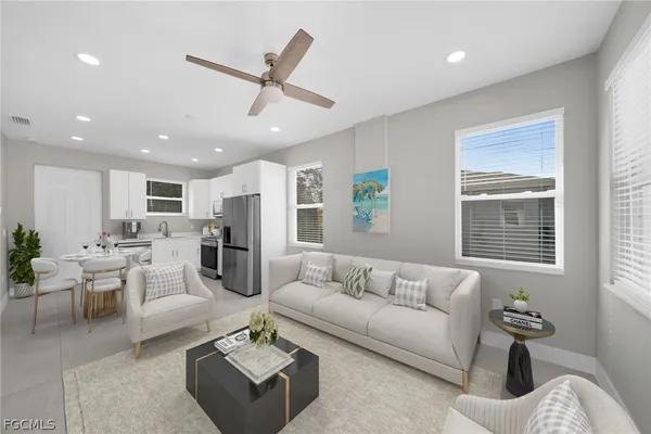 a living room with furniture kitchen view and a window
